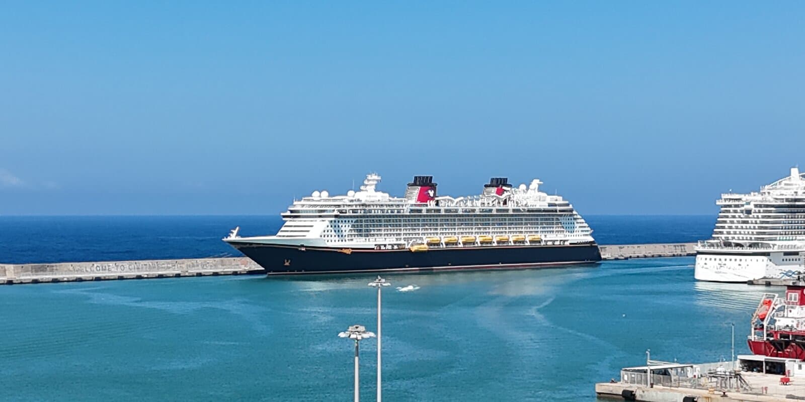 Disney Fantasy cruise ship with Mickey Mouse funnel stacks docked at Civitavecchia port