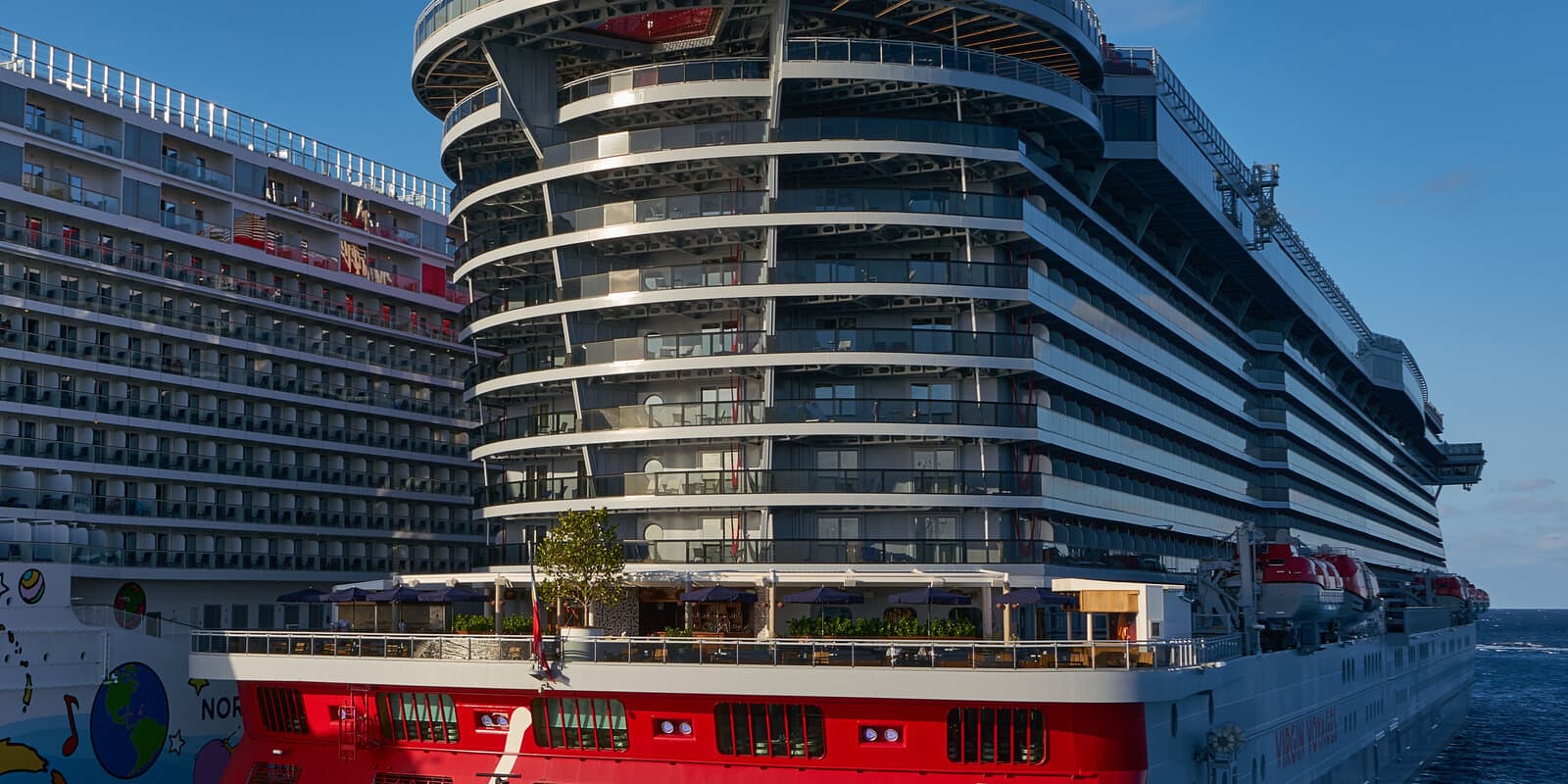 Stern view of Virgin Voyages cruise ship Scarlet Lady, a sister ship to Brilliant Lady, alongside a pier in Cozumel, Mexico