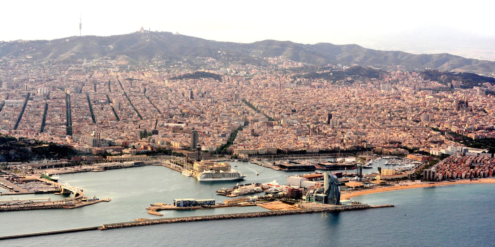 Cruise ship at Barcelona port with city skyline in the background — Mediterranean summer context without line-specific branding