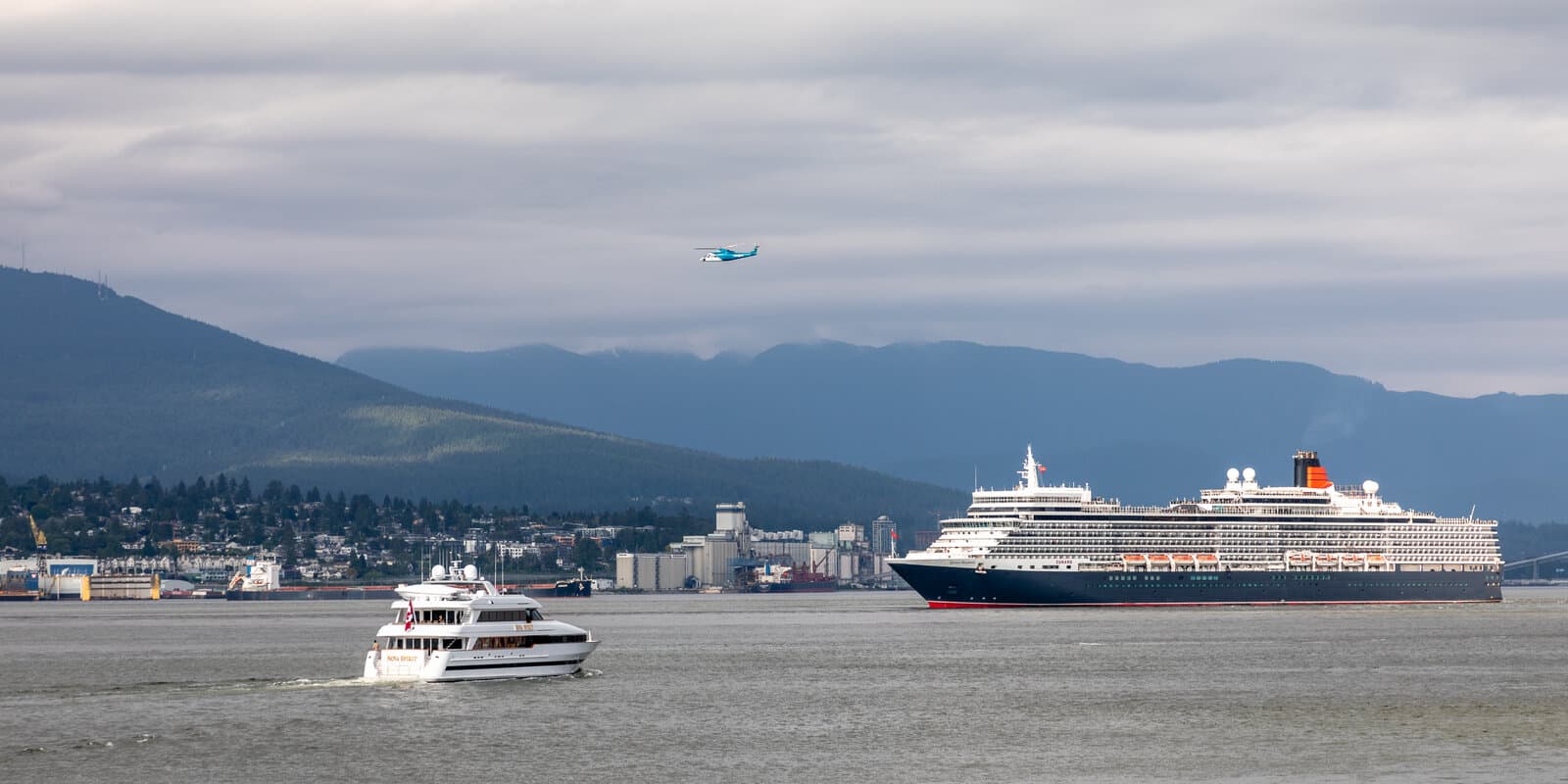Cunard's Queen Elizabeth cruise ship leaving Vancouver Harbour with mountains and city skyline in the background