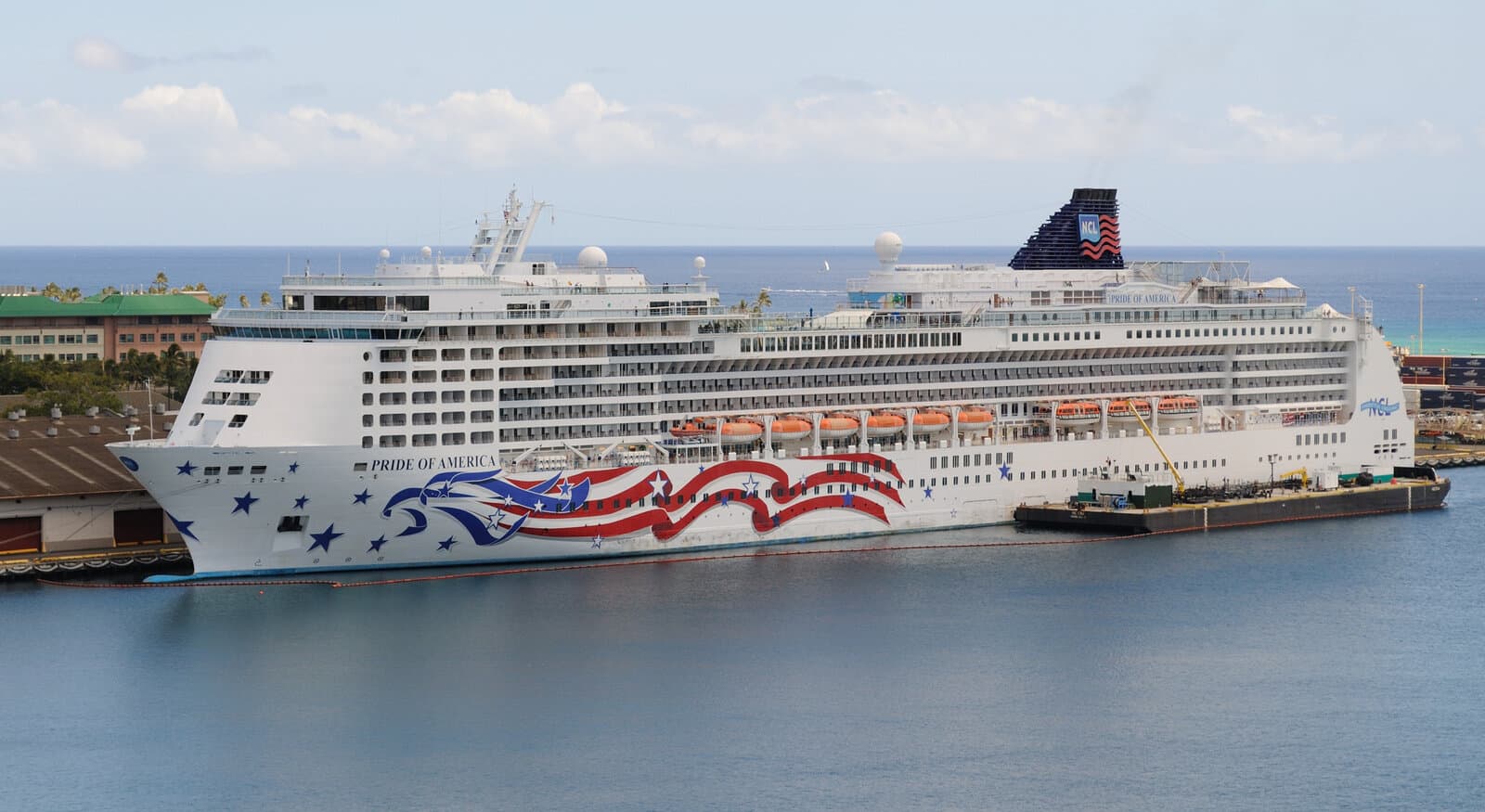 Norwegian Cruise Line Pride of America docked at Honolulu Harbor with patriotic hull art and Aloha Tower visible