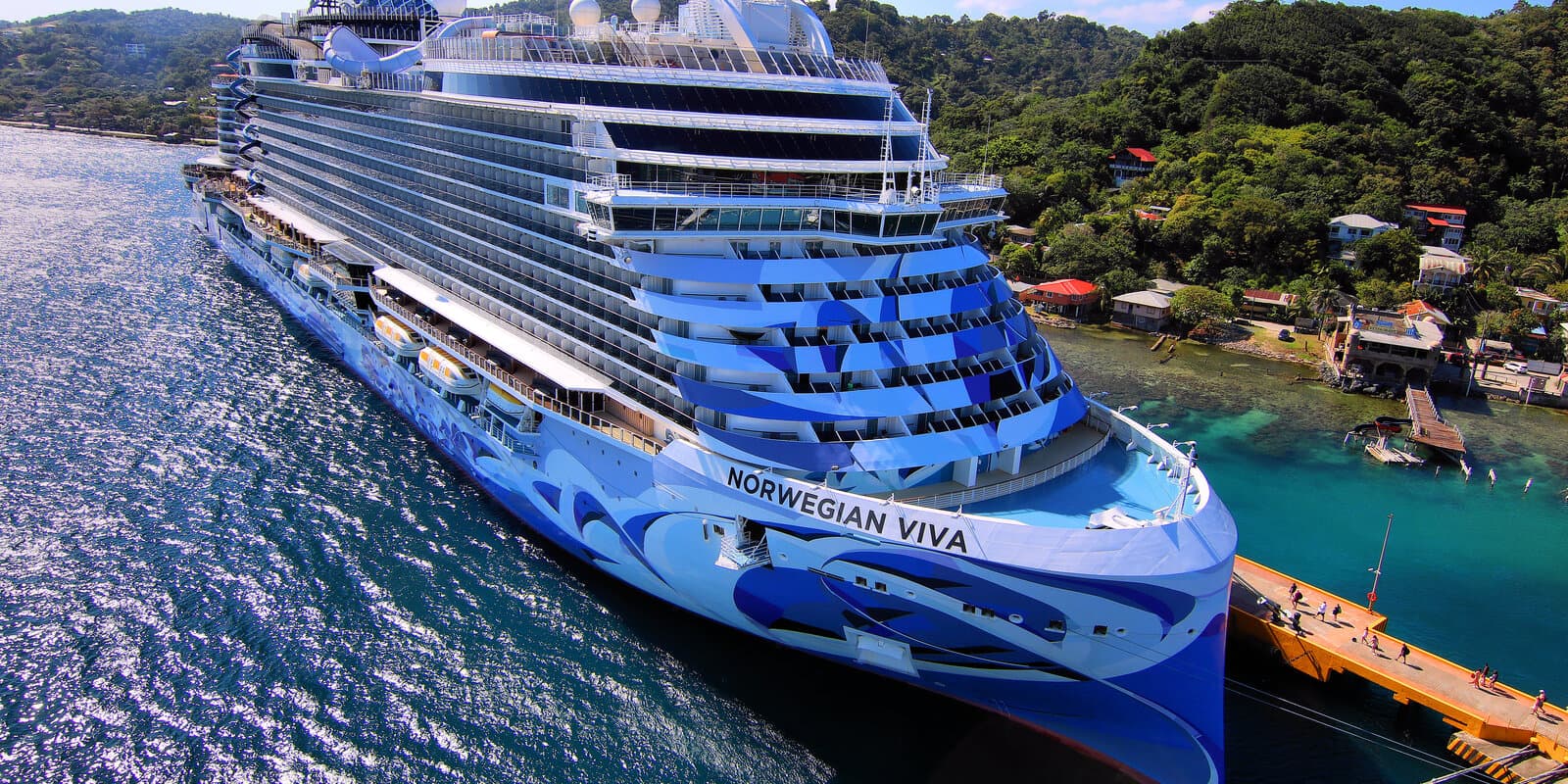 Norwegian Viva cruise ship docked at the Port of Roatan in Coxen Hole, Honduras, with tropical hills in the background