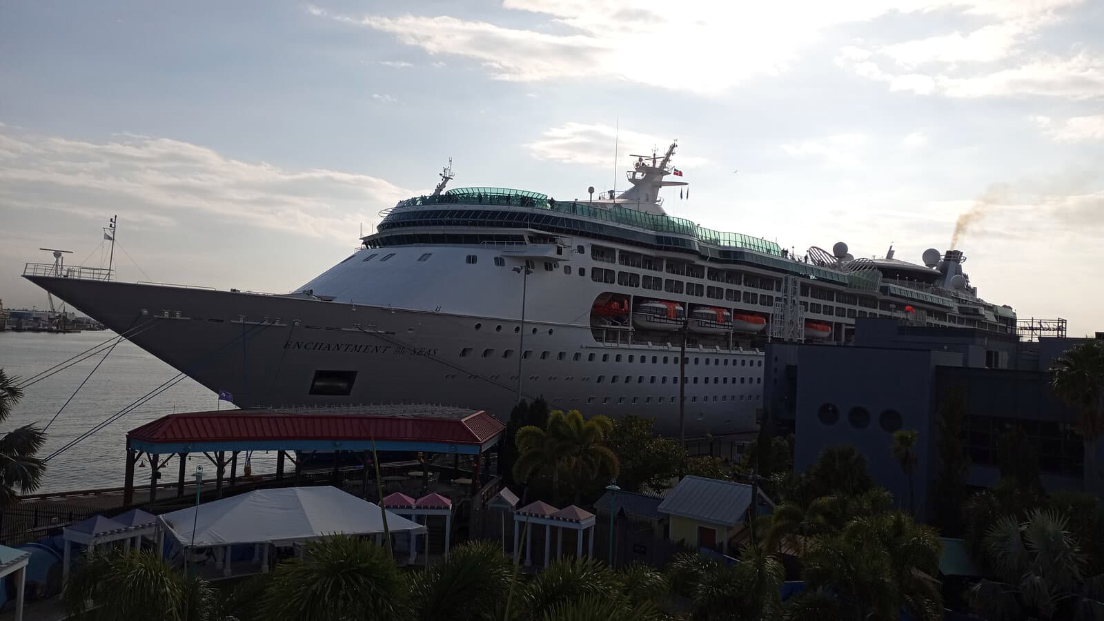 Enchantment of the Seas cruise ship docked at Port Tampa Bay Channel District terminals with port buildings and palm trees in the foreground