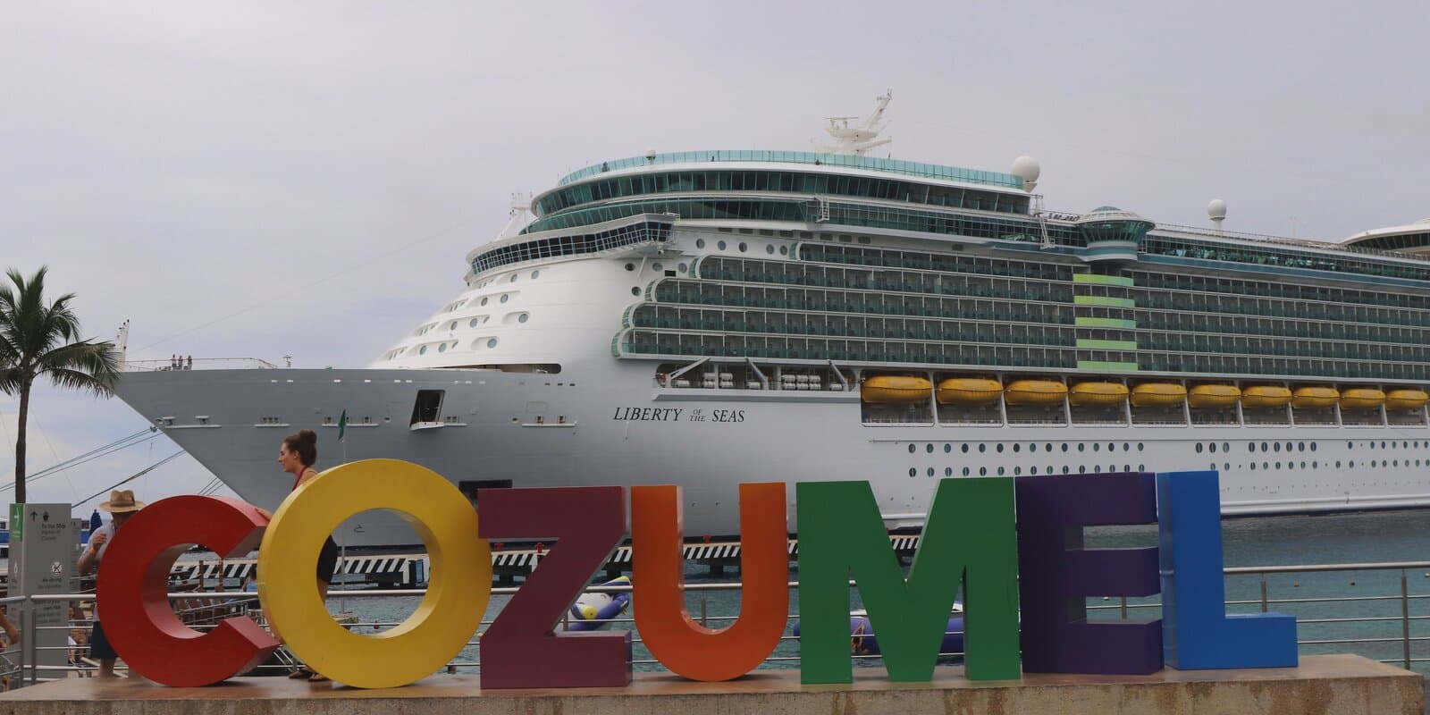 Colorful COZUMEL letters on the pier with Royal Caribbean Liberty of the Seas docked behind them