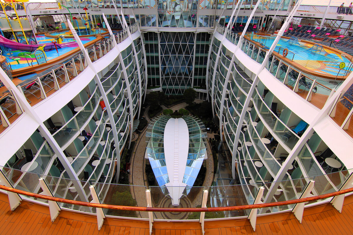 Central Park courtyard on Harmony of the Seas with trees, greenery, and open-air seating between cabin decks