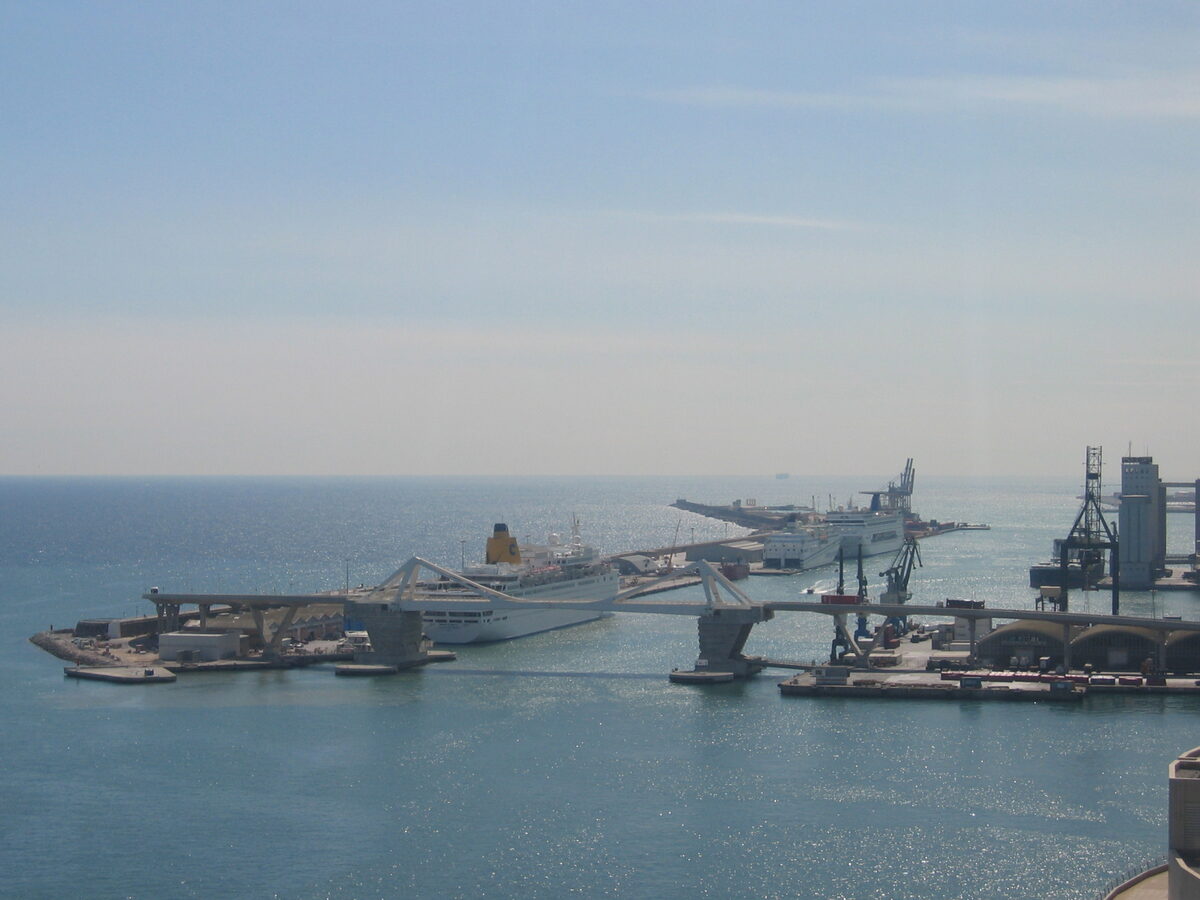 Cruise ships berthed at the Port of Barcelona pier with a bascule bridge in the foreground and the Mediterranean beyond