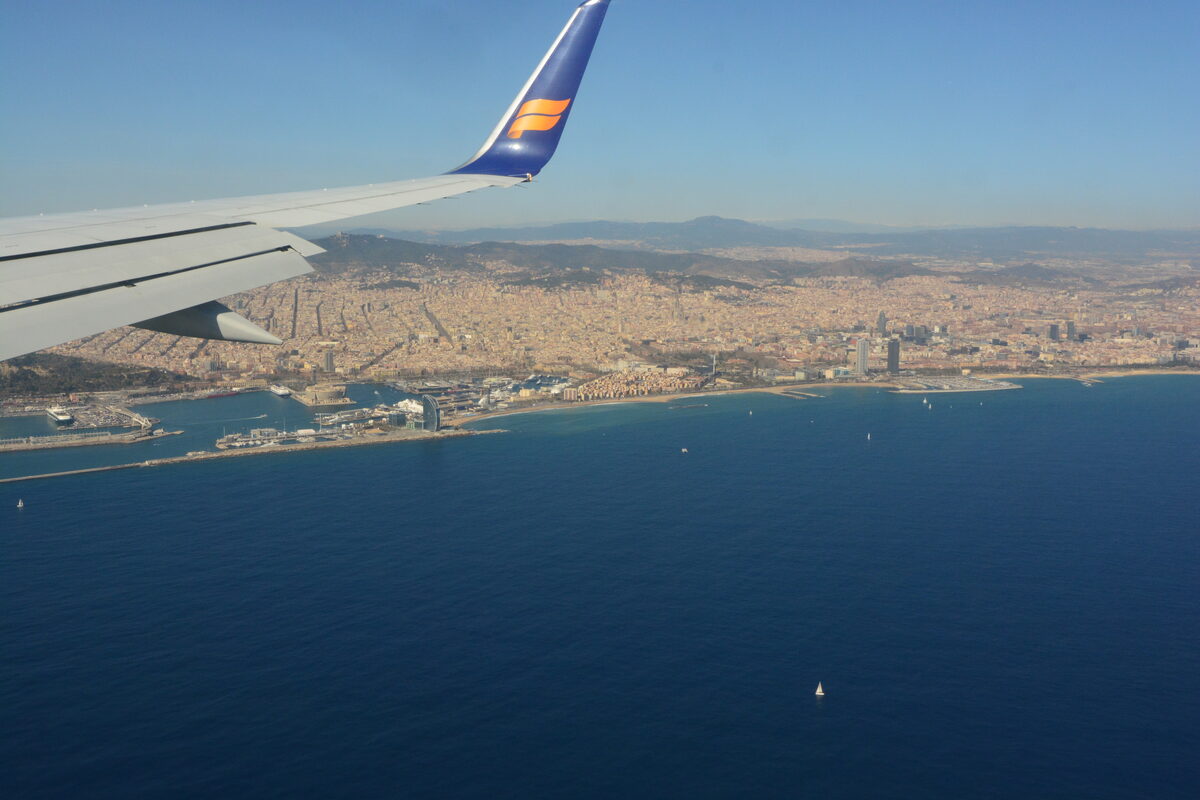 Aerial view of Barcelona's Mediterranean coastline with cruise port terminals, Barceloneta beach, and the city skyline