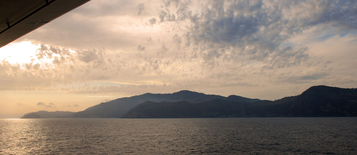 Dusk sky over the Italian Tyrrhenian coast and rolling hills as seen from a cruise ship at sea