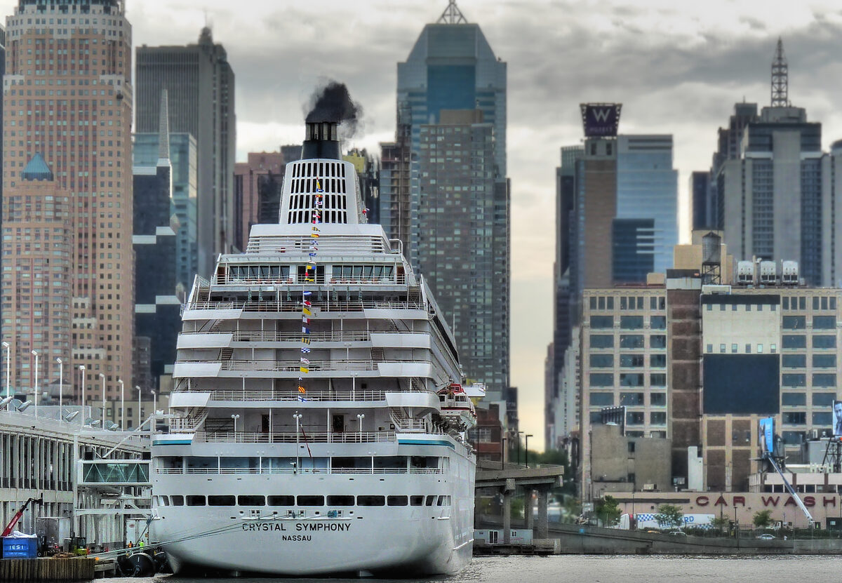 Crystal Symphony cruise ship docked at the Manhattan Cruise Terminal with the New York City skyline behind the stern