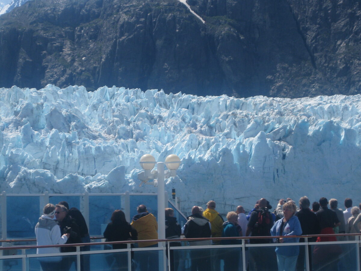 Cruise passengers in fleece and rain jackets at the ship rail viewing Margerie Glacier in Glacier Bay