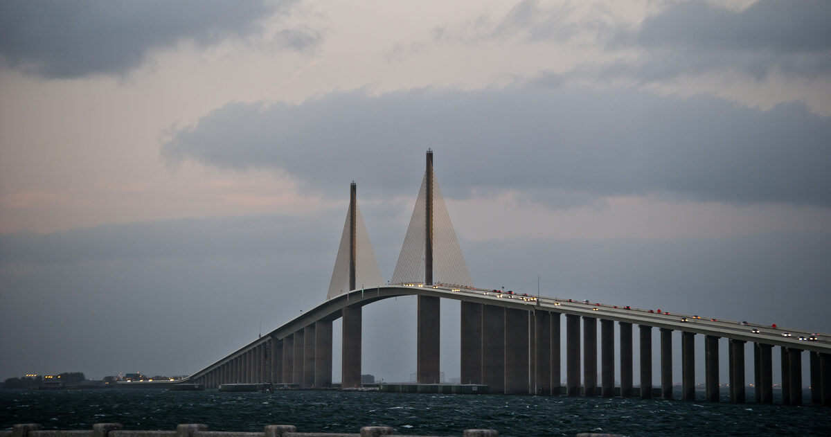 Sunshine Skyway cable-stayed bridge spanning Tampa Bay with vehicle lights on the deck at dusk