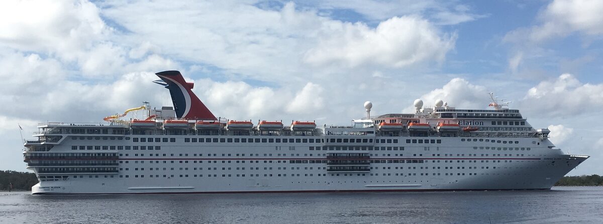 Carnival Elation arriving in Jacksonville in side profile, whale-tail funnel and ship name visible on the hull